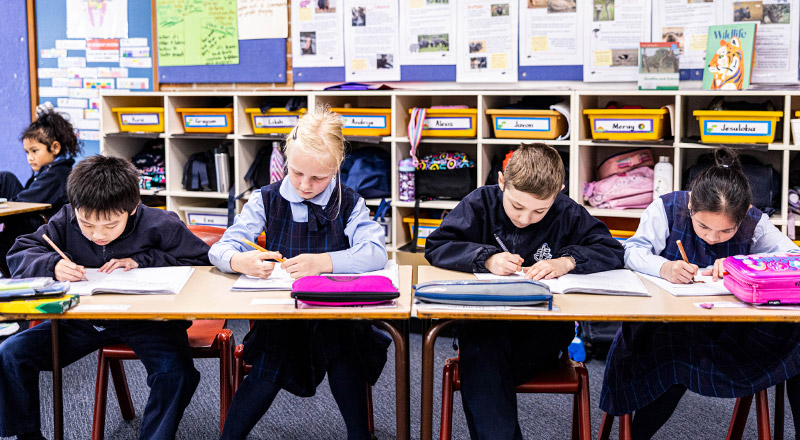 Students writing in their exercise books at St John Vianney's Primary School Doonside