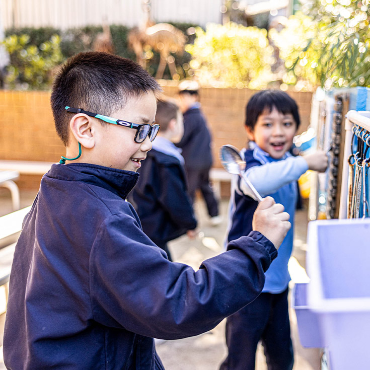 Students playing in the outdoor sensory garden at St John Vianney's Primary School Doonside