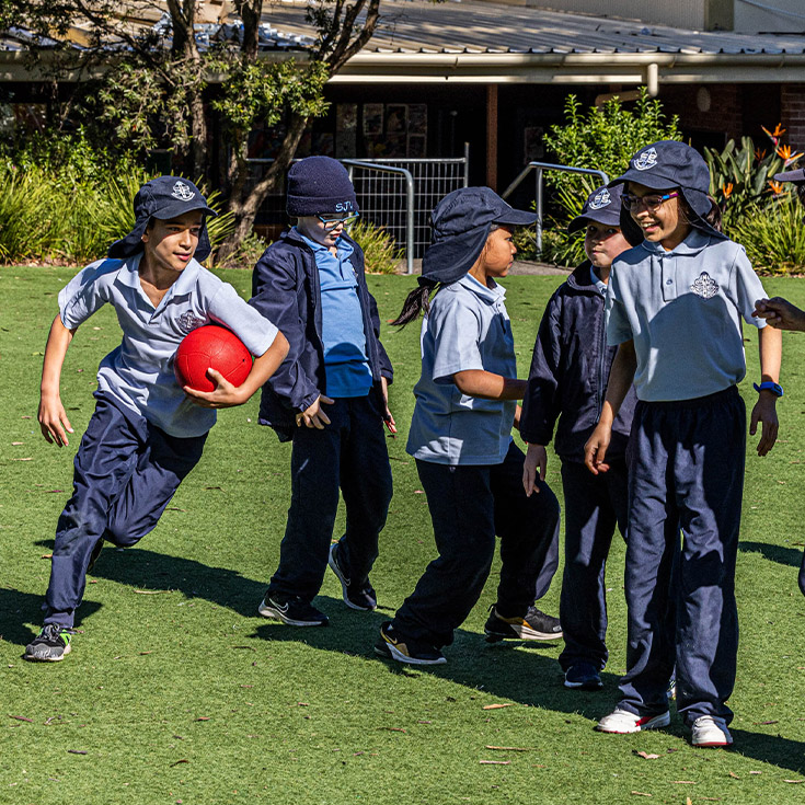 Students playing games together on the school oval at St John Vianney's Primary School Doonside